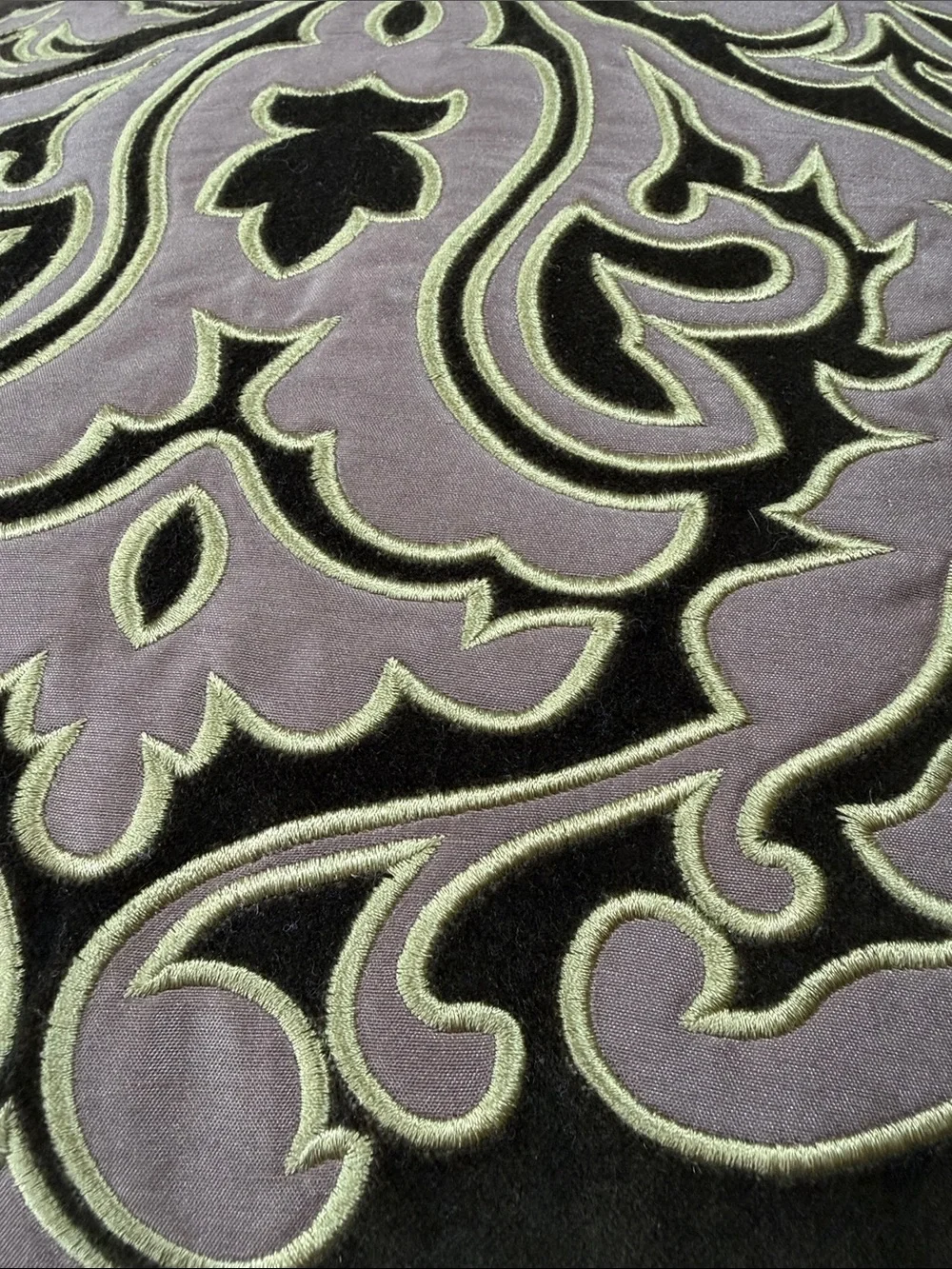 Reba green velour pillow with embroidered scroll design on front.
